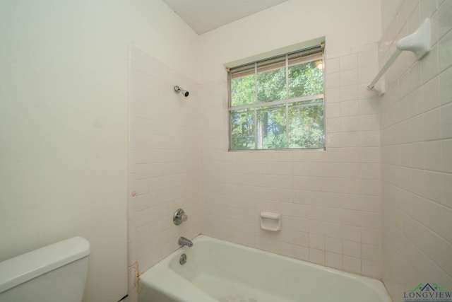 bathroom with tiled shower / bath and toilet