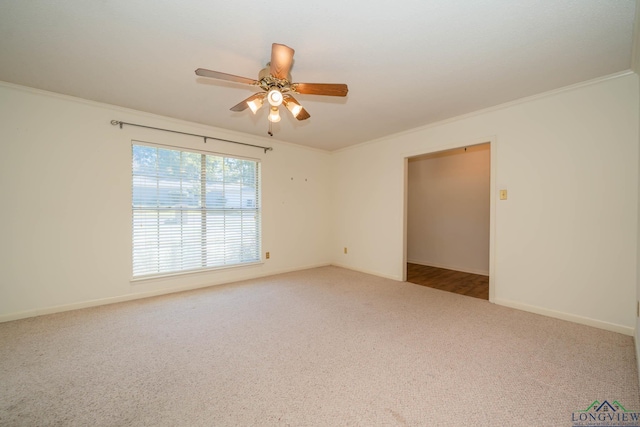 carpeted empty room with ceiling fan and crown molding