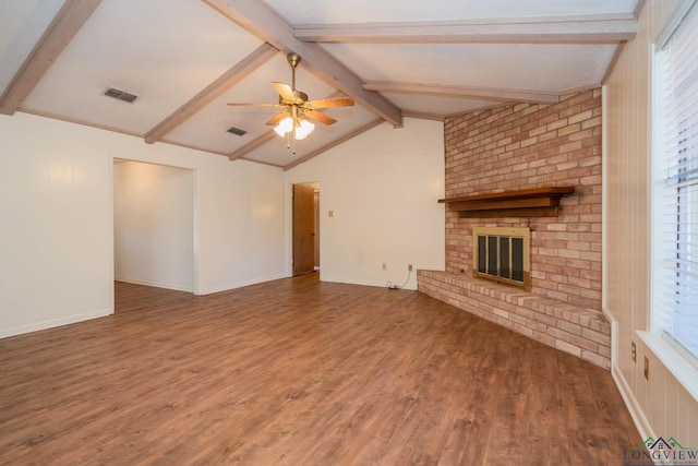 unfurnished living room featuring dark hardwood / wood-style flooring, a wealth of natural light, ceiling fan, lofted ceiling with beams, and a fireplace