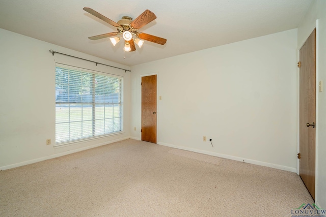 unfurnished room with light colored carpet and ceiling fan