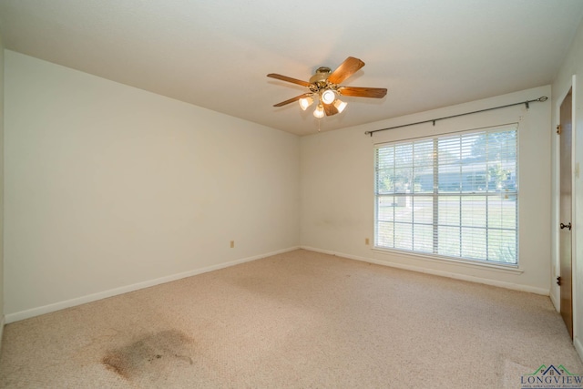 carpeted spare room with ceiling fan