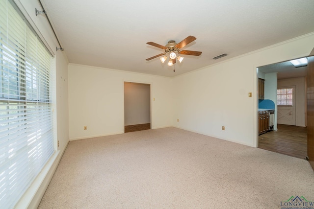 carpeted empty room with ceiling fan and ornamental molding