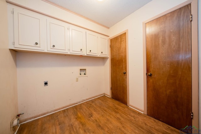 laundry room with electric dryer hookup, cabinets, hookup for a washing machine, light wood-type flooring, and a textured ceiling