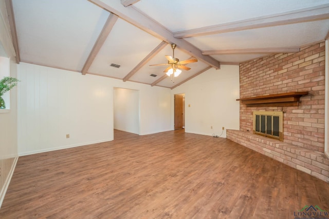 unfurnished living room featuring ceiling fan, hardwood / wood-style floors, lofted ceiling with beams, and a brick fireplace