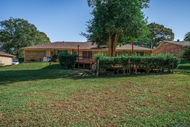 rear view of house with a wooden deck and a lawn