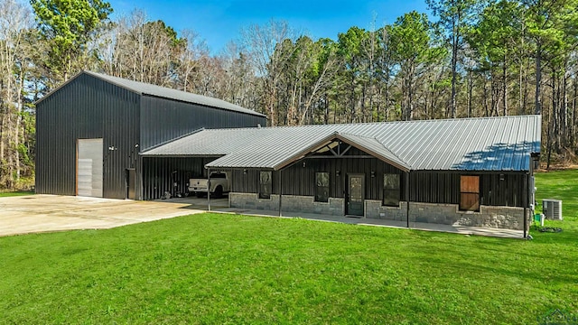 view of front of property with a garage, an outdoor structure, a front yard, and central air condition unit