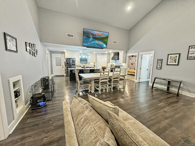 dining area with a towering ceiling and dark hardwood / wood-style floors