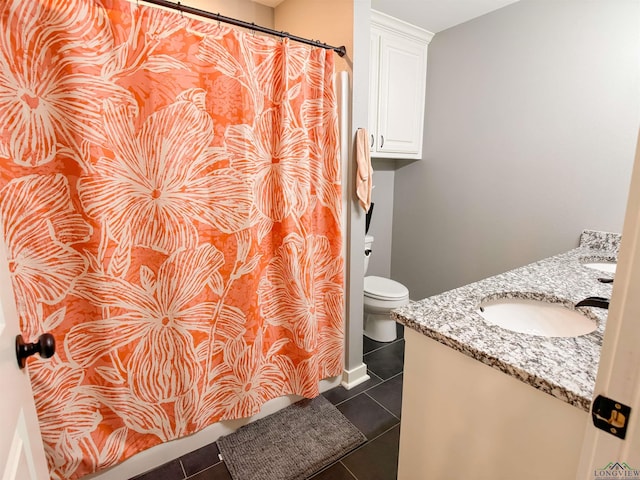 bathroom featuring vanity, tile patterned floors, and toilet