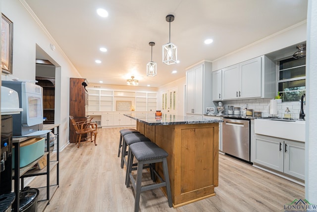 kitchen featuring backsplash, decorative light fixtures, dark stone countertops, dishwasher, and a kitchen island