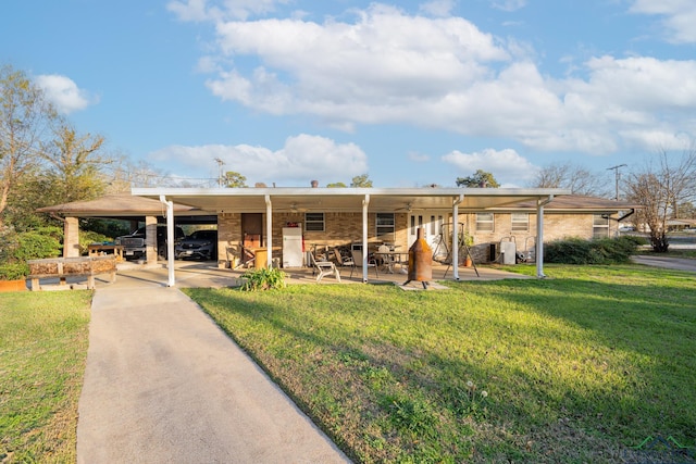 view of front of home featuring ceiling fan, a front lawn, and a carport