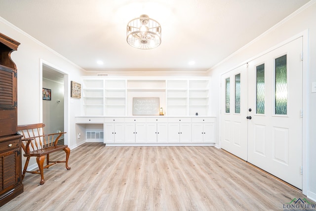 interior space featuring light hardwood / wood-style floors, crown molding, and an inviting chandelier