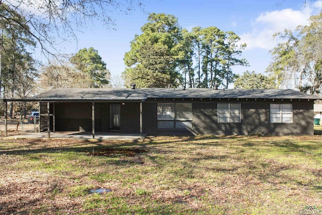 back of property featuring a patio area and a lawn