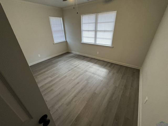 spare room featuring hardwood / wood-style flooring, ceiling fan, and crown molding