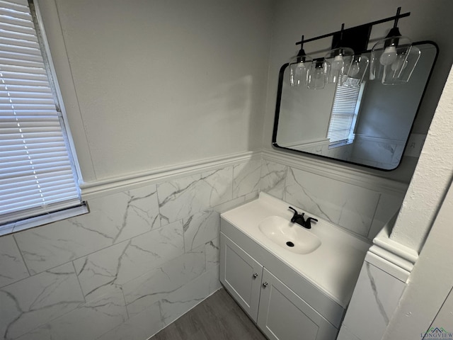 bathroom featuring hardwood / wood-style flooring, vanity, and tile walls