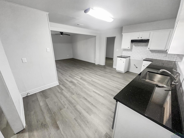 kitchen featuring sink, white cabinetry, ceiling fan, light hardwood / wood-style floors, and backsplash