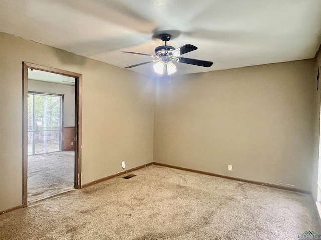 spare room with ceiling fan and carpet