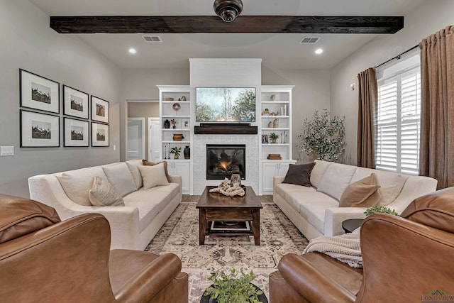 living room with a tile fireplace and beam ceiling