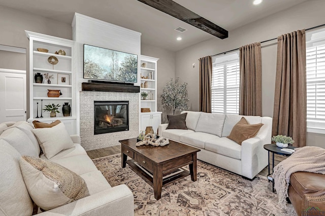 living room featuring beamed ceiling and light hardwood / wood-style flooring