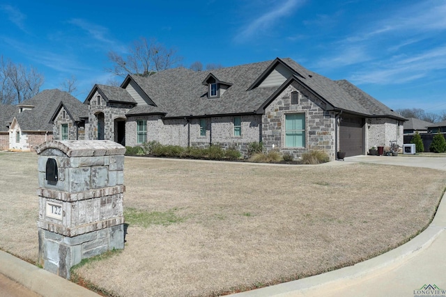 french country style house featuring a front lawn and a garage