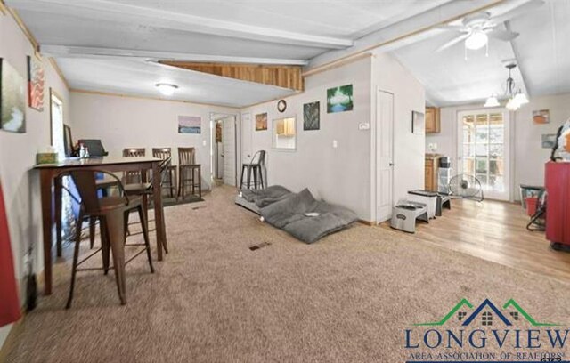 interior space featuring carpet, lofted ceiling with beams, and ceiling fan