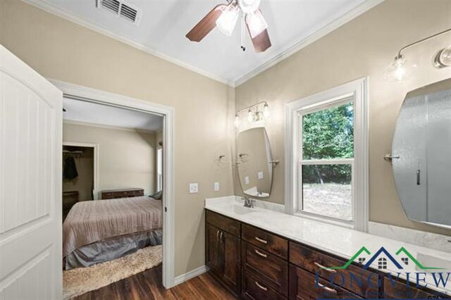 bathroom with ceiling fan, vanity, ornamental molding, and hardwood / wood-style flooring