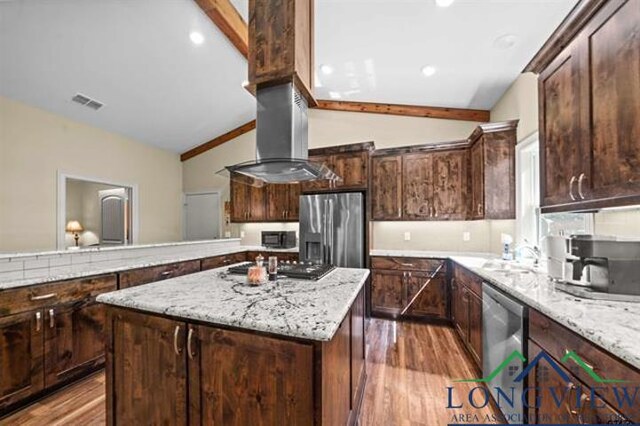 kitchen with dark brown cabinets, a kitchen island, lofted ceiling, and appliances with stainless steel finishes