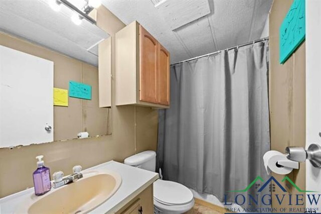 bathroom featuring vanity, curtained shower, and toilet