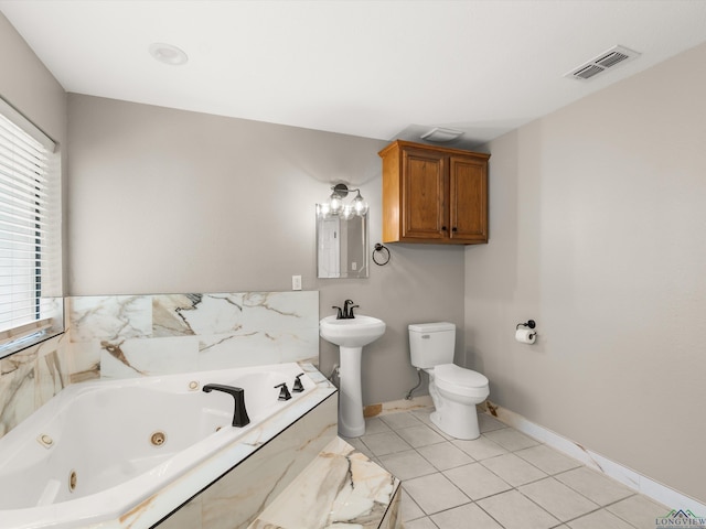 2015 W Lake Dr, Gladewater, TX 75647 - bathroom featuring a jetted tub, toilet, a sink, baseboards, and tile patterned floors