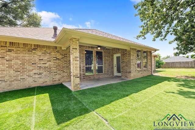 rear view of property featuring a yard and a patio area