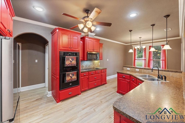 kitchen featuring backsplash, black appliances, crown molding, sink, and light hardwood / wood-style floors