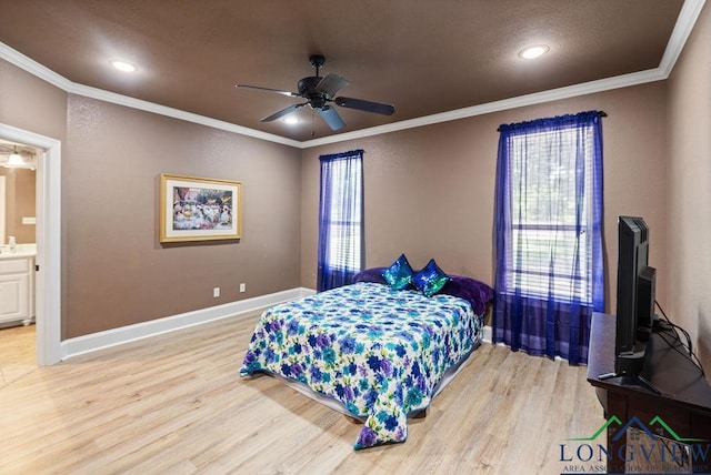 bedroom featuring light hardwood / wood-style floors, ensuite bath, ceiling fan, and crown molding