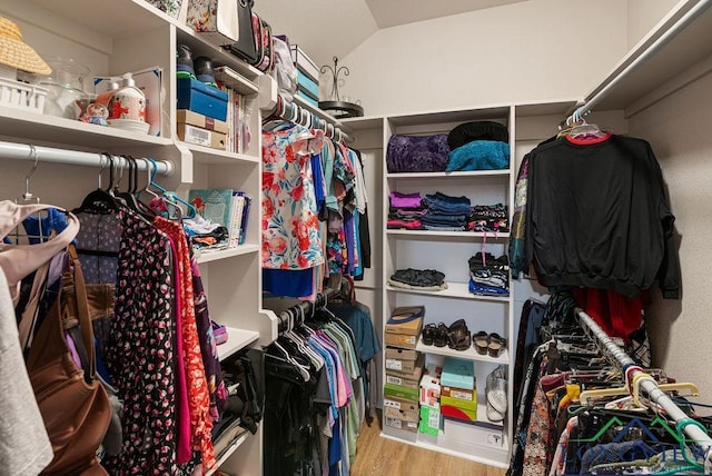 walk in closet featuring vaulted ceiling and light hardwood / wood-style flooring