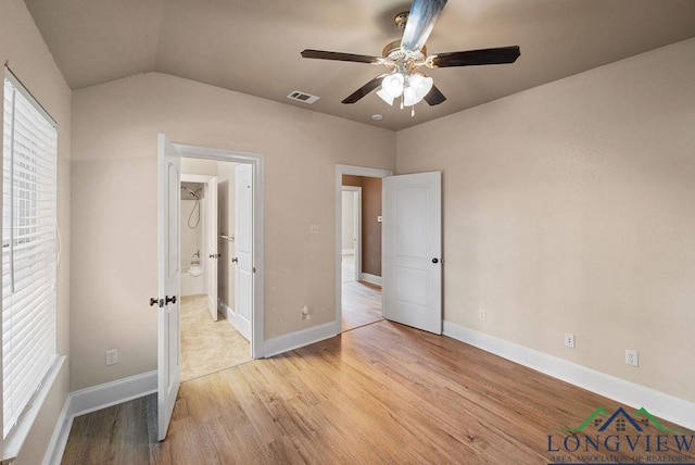 unfurnished bedroom with ceiling fan, light hardwood / wood-style floors, and lofted ceiling