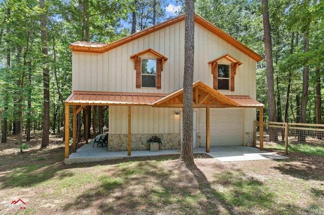 12493 S State Highway 87, Shelbyville, TX 75973 - view of front of house with an attached garage, metal roof, stone siding, and board and batten siding