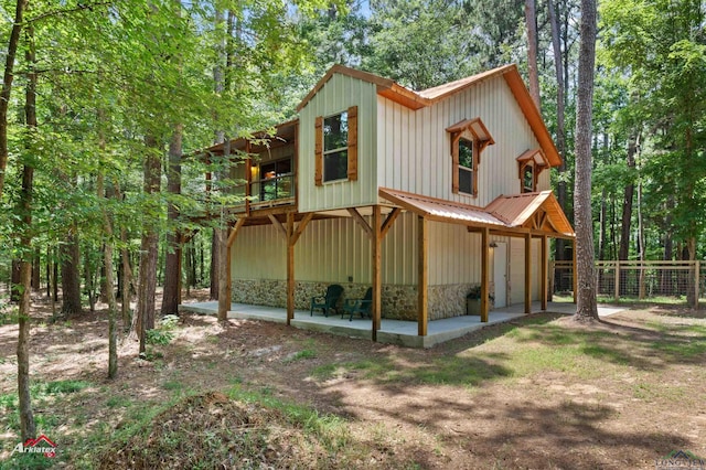 12493 S State Highway 87, Shelbyville, TX 75973 - view of property exterior featuring a patio area, a balcony, and board and batten siding