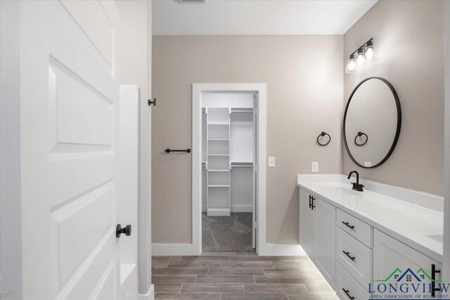 16226 Crossing Cir, Lindale, TX 75771 - full bath with wood tiled floor, baseboards, vanity, and a walk in closet