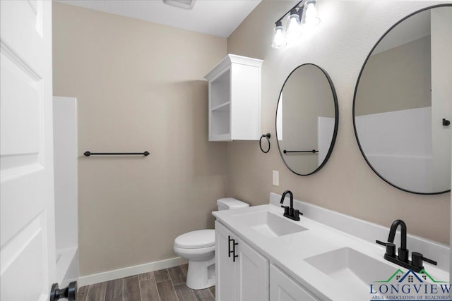 16226 Crossing Cir, Lindale, TX 75771 - full bath featuring baseboards, a sink, wood finished floors, and toilet