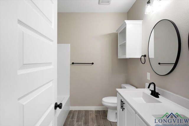16226 Crossing Cir, Lindale, TX 75771 - bathroom with a tub, wood tiled floor, baseboards, vanity, and toilet