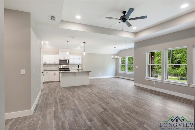 16226 Crossing Cir, Lindale, TX 75771 - unfurnished living room with baseboards, visible vents, a tray ceiling, and light wood-style floors