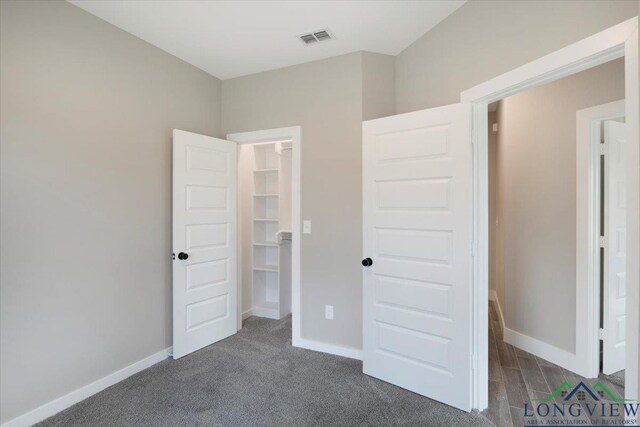 16226 Crossing Cir, Lindale, TX 75771 - unfurnished bedroom with carpet floors, baseboards, visible vents, and a walk in closet