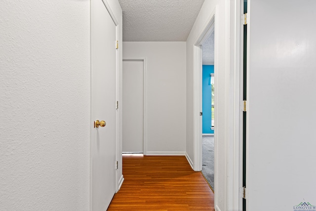 1208 Marigold Ln, Longview, TX 75604 - hall featuring wood finished floors, a textured ceiling, and baseboards