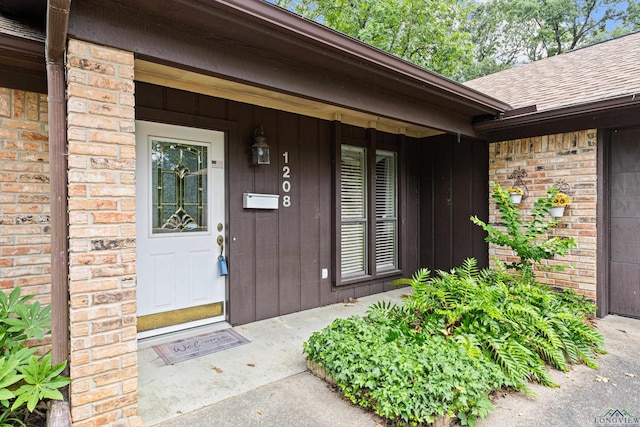 1208 Marigold Ln, Longview, TX 75604 - doorway to property featuring a shingled roof and brick siding