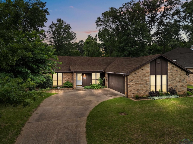1208 Marigold Ln, Longview, TX 75604 - mid-century modern home with brick siding, driveway, a front yard, an attached garage, and a shingled roof