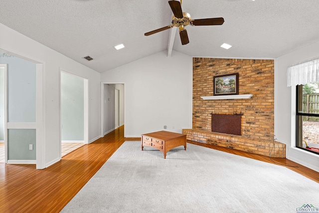 1208 Marigold Ln, Longview, TX 75604 - living room featuring wood finished floors, a textured ceiling, a fireplace, a ceiling fan, and baseboards