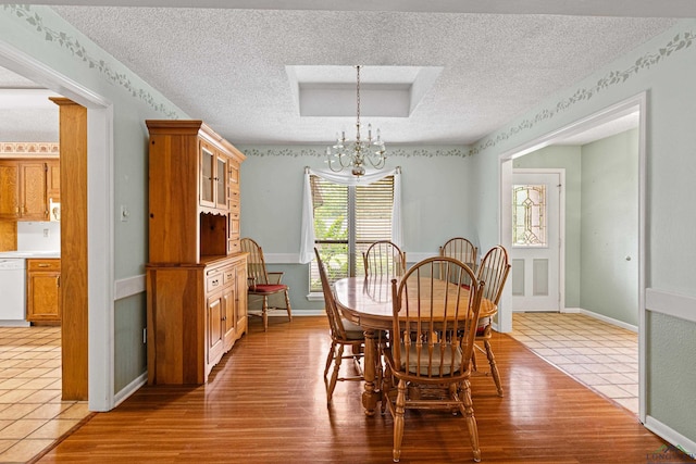 1208 Marigold Ln, Longview, TX 75604 - dining room with a textured ceiling, a chandelier, wood finished floors, and baseboards