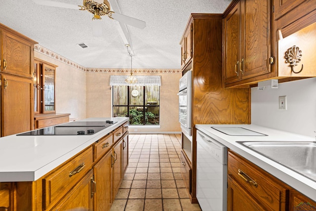 1208 Marigold Ln, Longview, TX 75604 - kitchen featuring white appliances, light countertops, a textured ceiling, and brown cabinetry