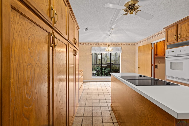1208 Marigold Ln, Longview, TX 75604 - kitchen with oven, a textured ceiling, black electric cooktop, a chandelier, and brown cabinetry
