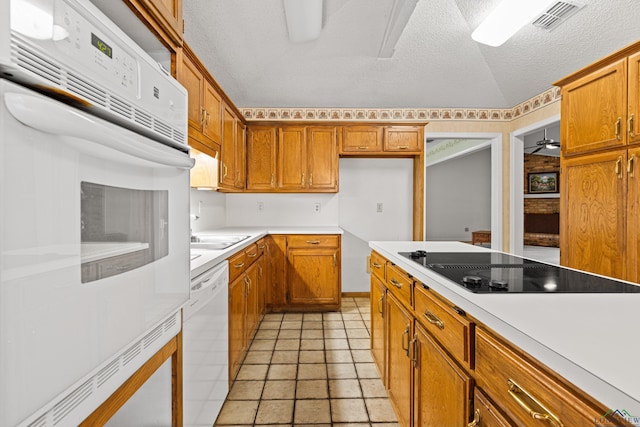 1208 Marigold Ln, Longview, TX 75604 - kitchen featuring white appliances, brown cabinets, light countertops, and a textured ceiling