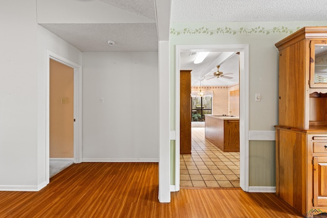 1208 Marigold Ln, Longview, TX 75604 - corridor featuring a textured ceiling, wood finished floors, and baseboards