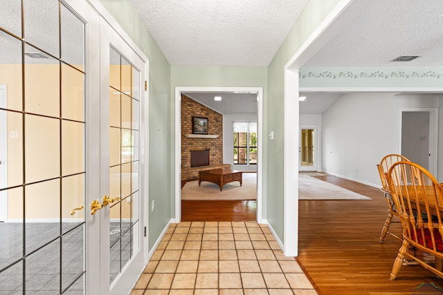 1208 Marigold Ln, Longview, TX 75604 - hallway featuring light wood finished floors, a textured ceiling, french doors, and baseboards